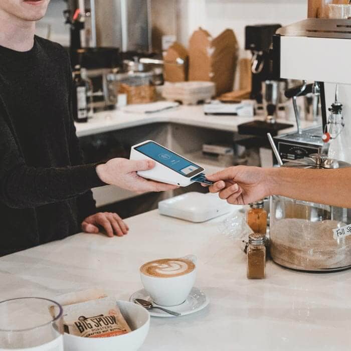 Business Loans for Cafes and Coffee Shops - Owner taking card payment from customer