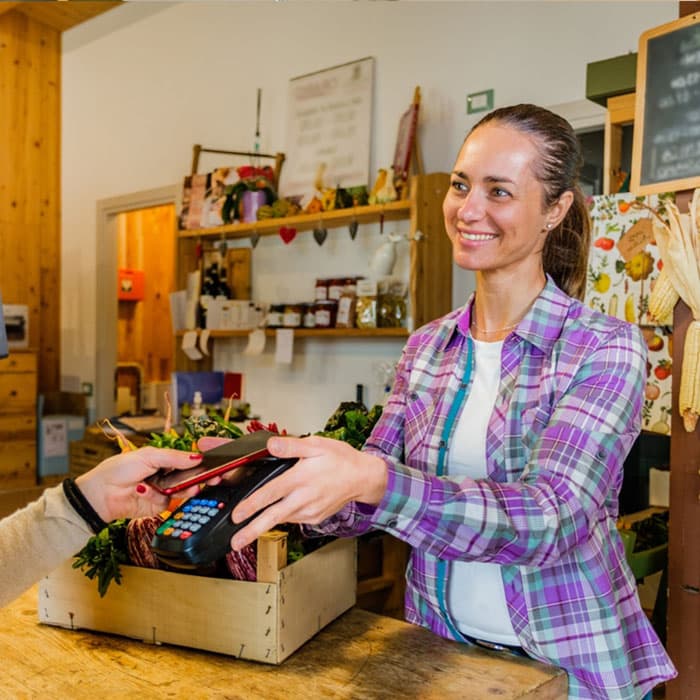 Farm shop business owner taking customer card payment